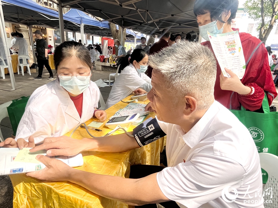 一位市民在展位前測量血壓。人民網(wǎng) 錢嘉禾攝