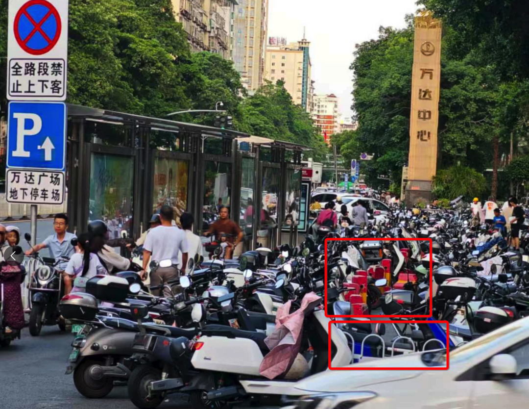 浦西公交站背后路段設(shè)置了非機(jī)動車停車區(qū)域，但仍有大量電動車直接停放在白色護(hù)欄和紅色隔離墩（紅框位置）外的非機(jī)動車道上。李先生攝于7月2日